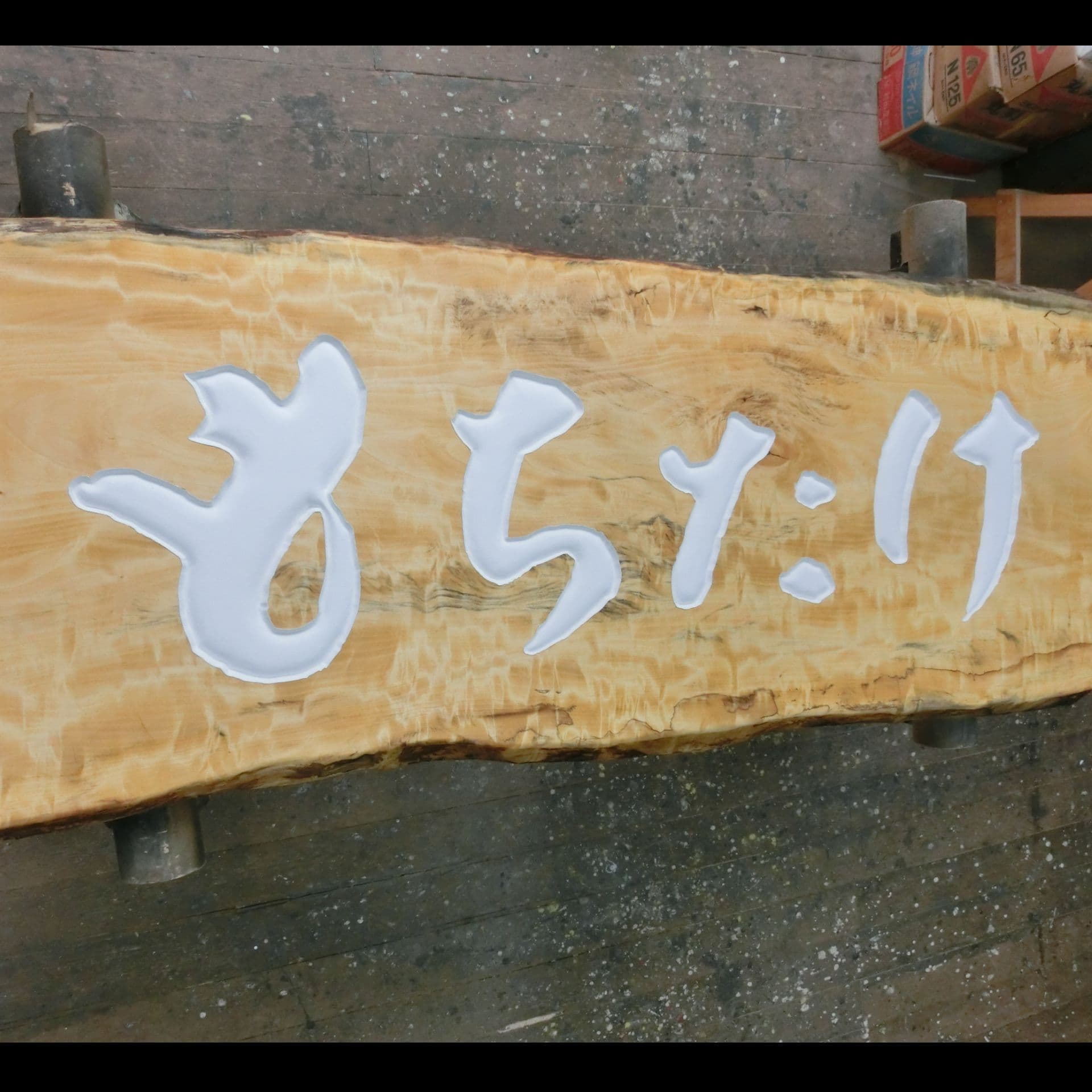 自然な形の木の板に白い文字を彫刻、品の良い看板