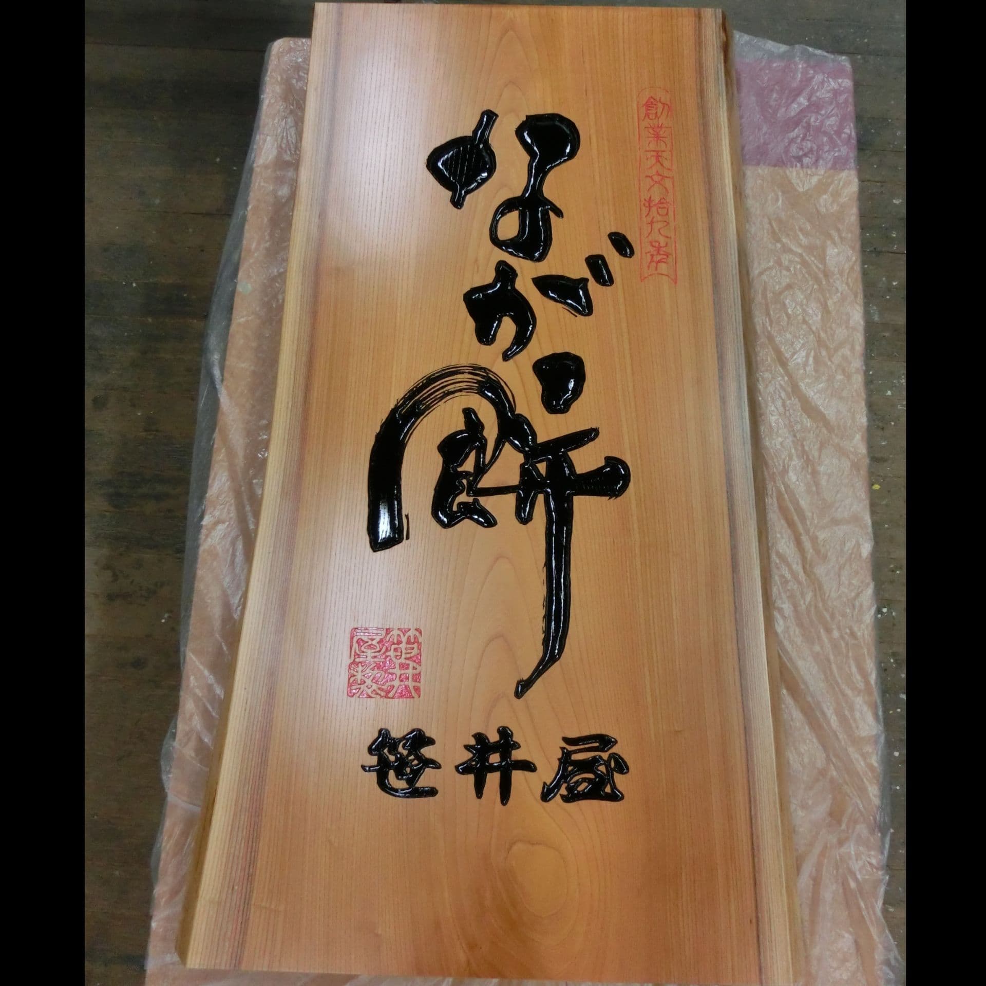 自然な木の形の板に文字を彫って制作