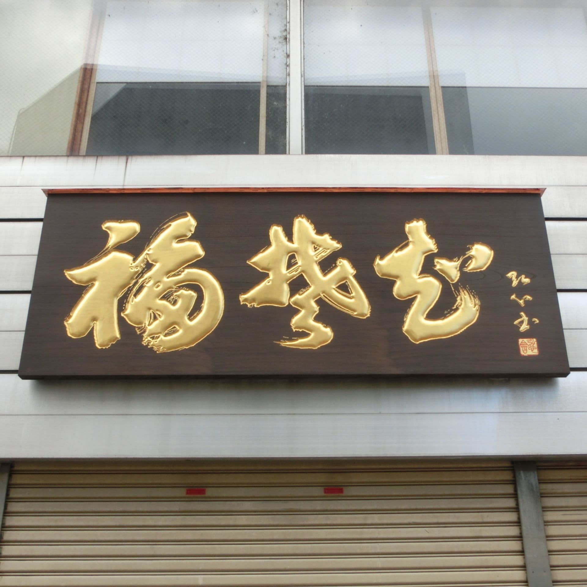 濃い板の色に金色の文字が映える越前そばの名店の看板