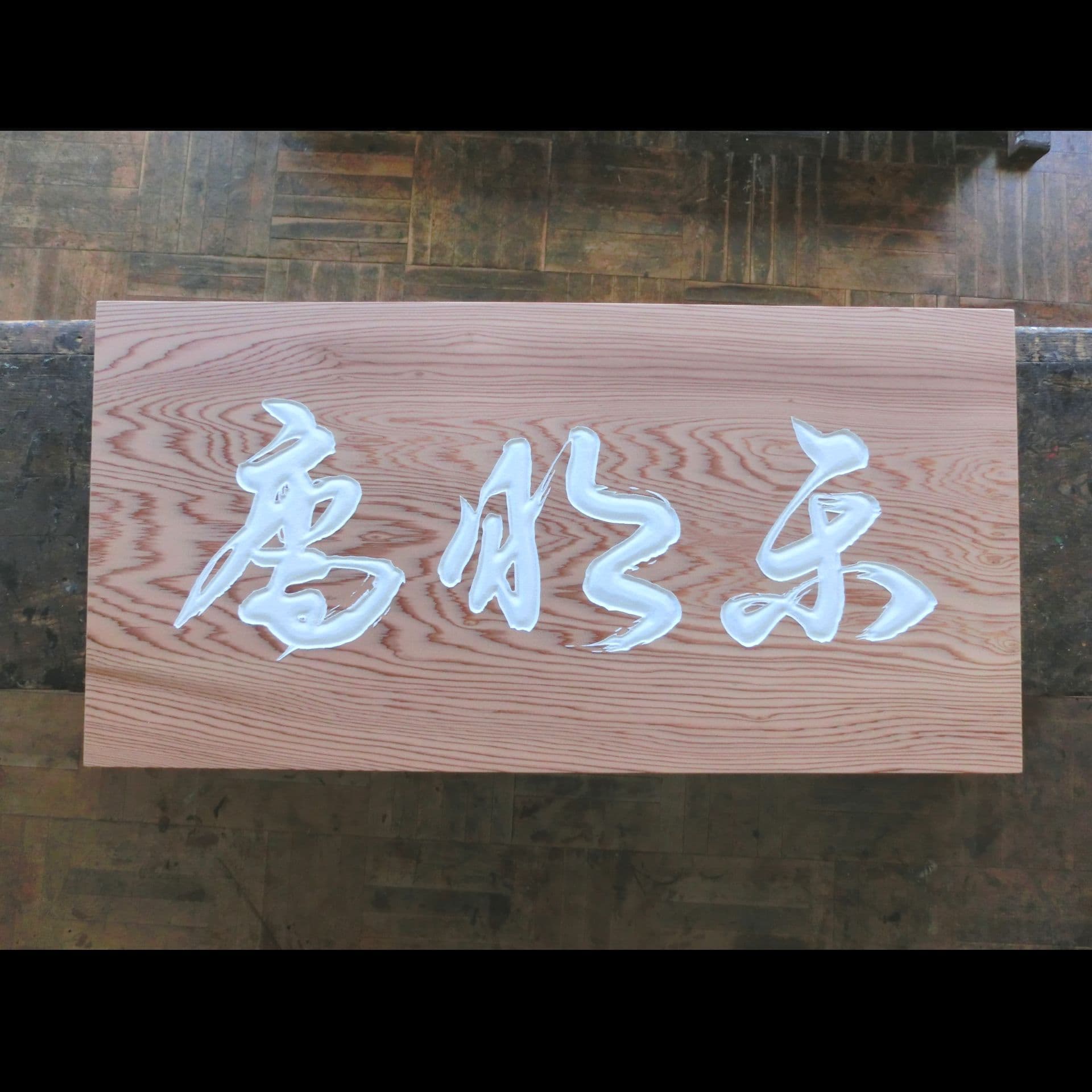 清々しい印象の木の板に茶室の名前を彫った扁額、看板