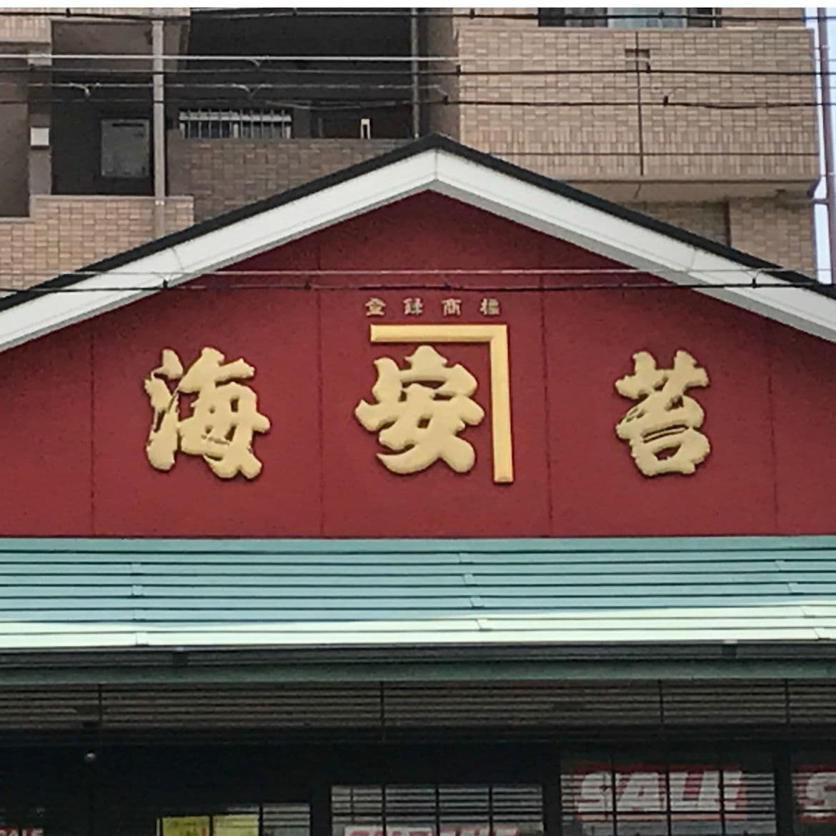 壁に金色の立体の文字が着いている海苔店の看板