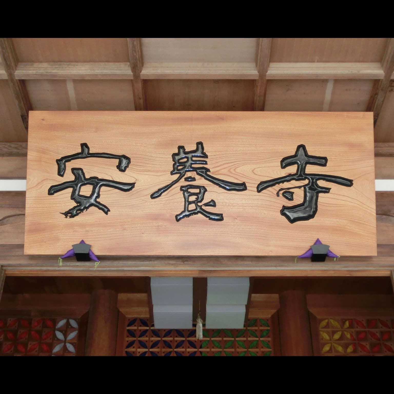 木の板にお寺の名前を彫ってある看板、扁額
