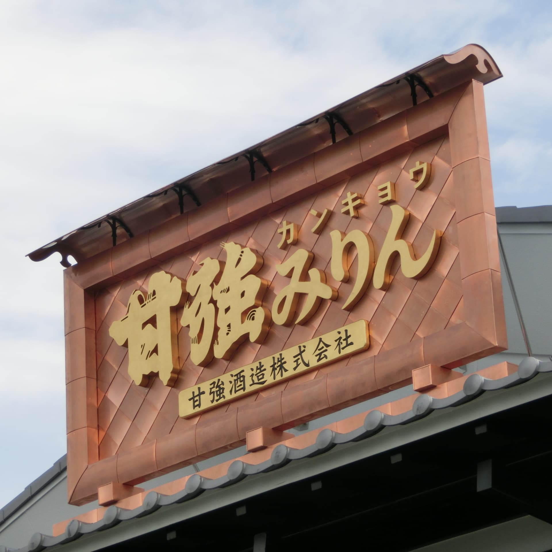 倉の入り口に銅板金の枠に金文字のみりん醸造の看板
