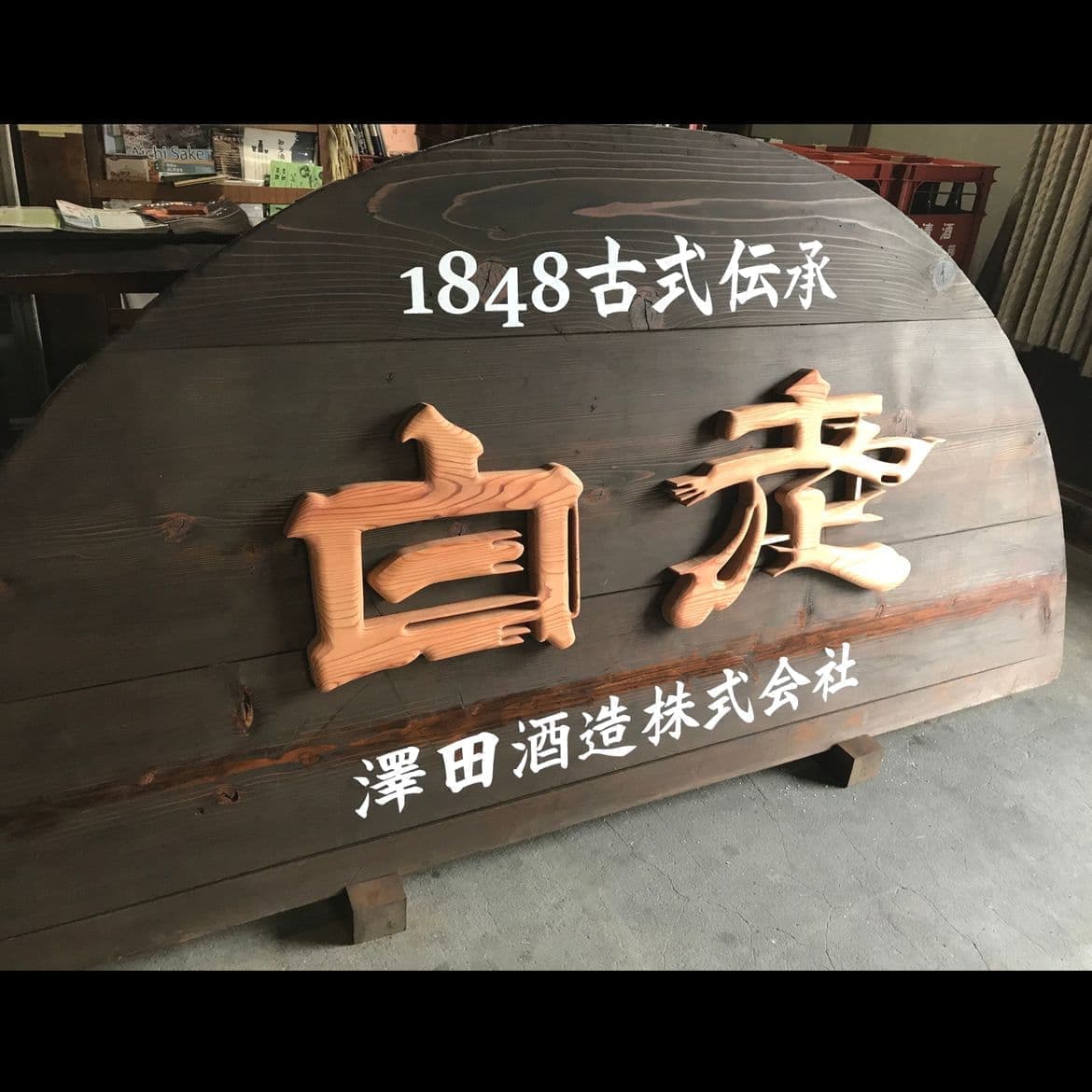 酒蔵で使った木の蓋に切り抜いた文字の酒造会社の看板