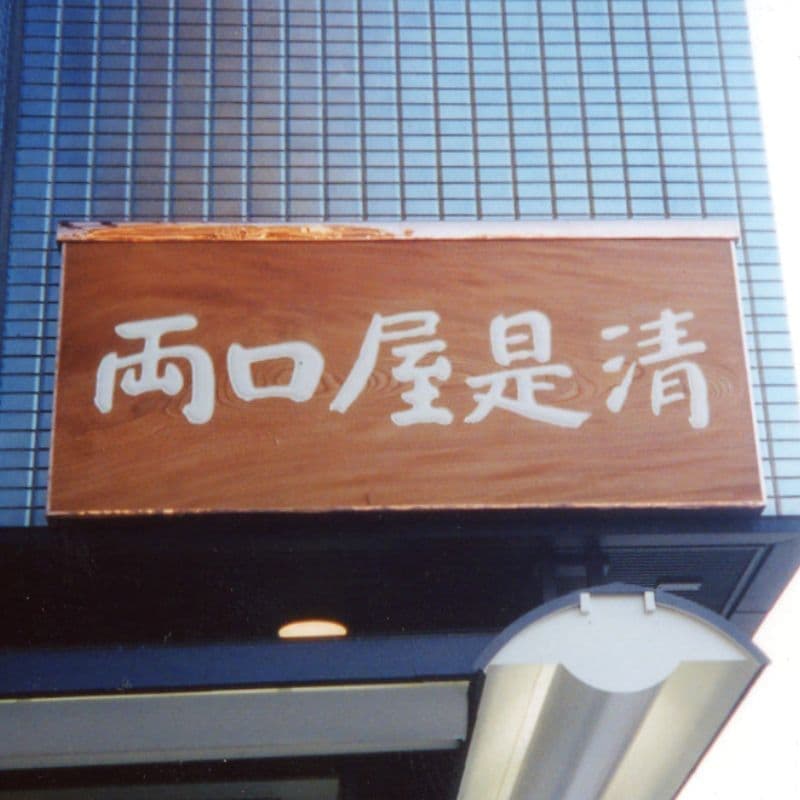 木の板に白い文字で店名が書いてある和菓子店の看板